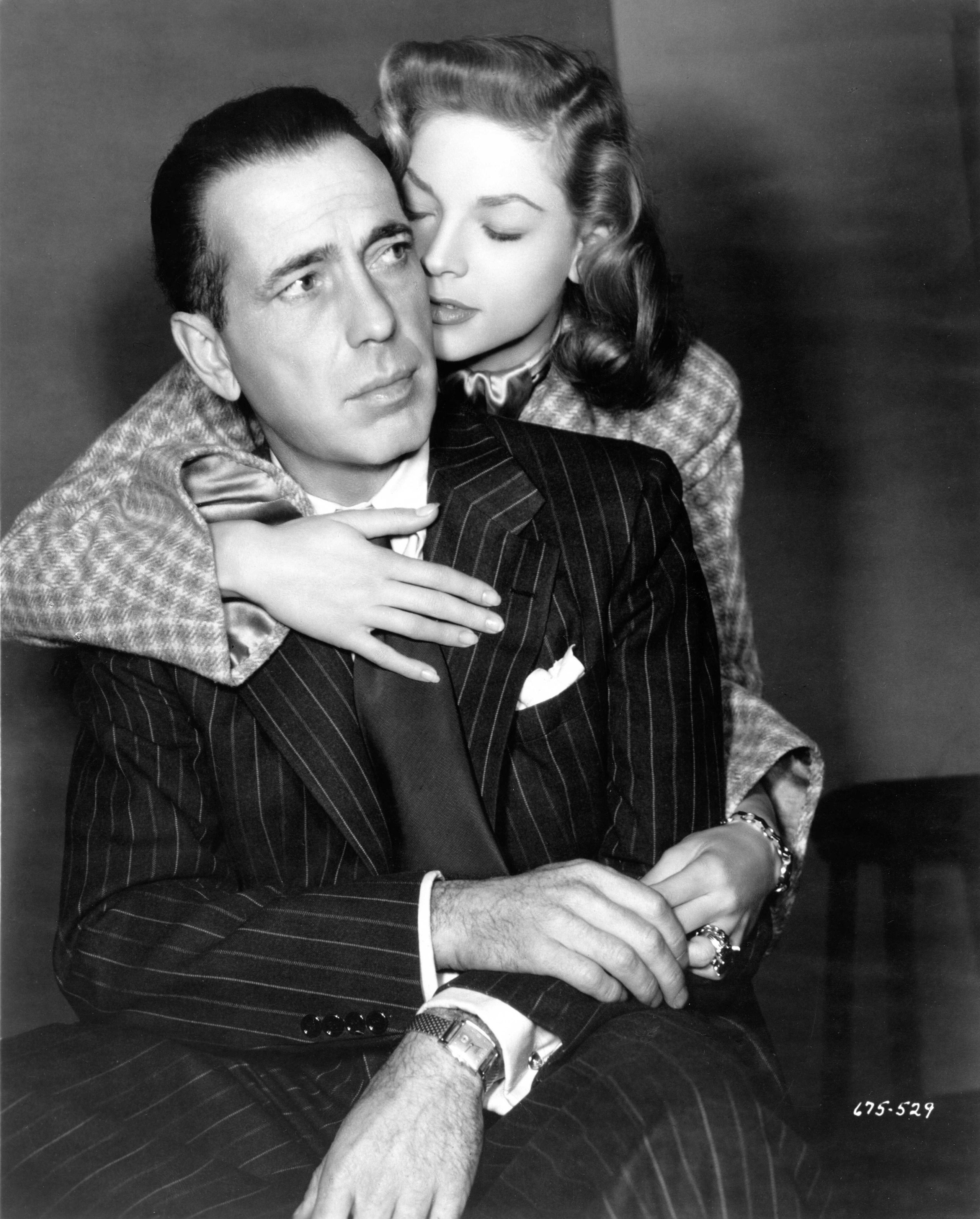 Image may contain Humphrey Bogart Lauren Bacall Clothing Formal Wear Suit Body Part Finger Hand Person and Adult