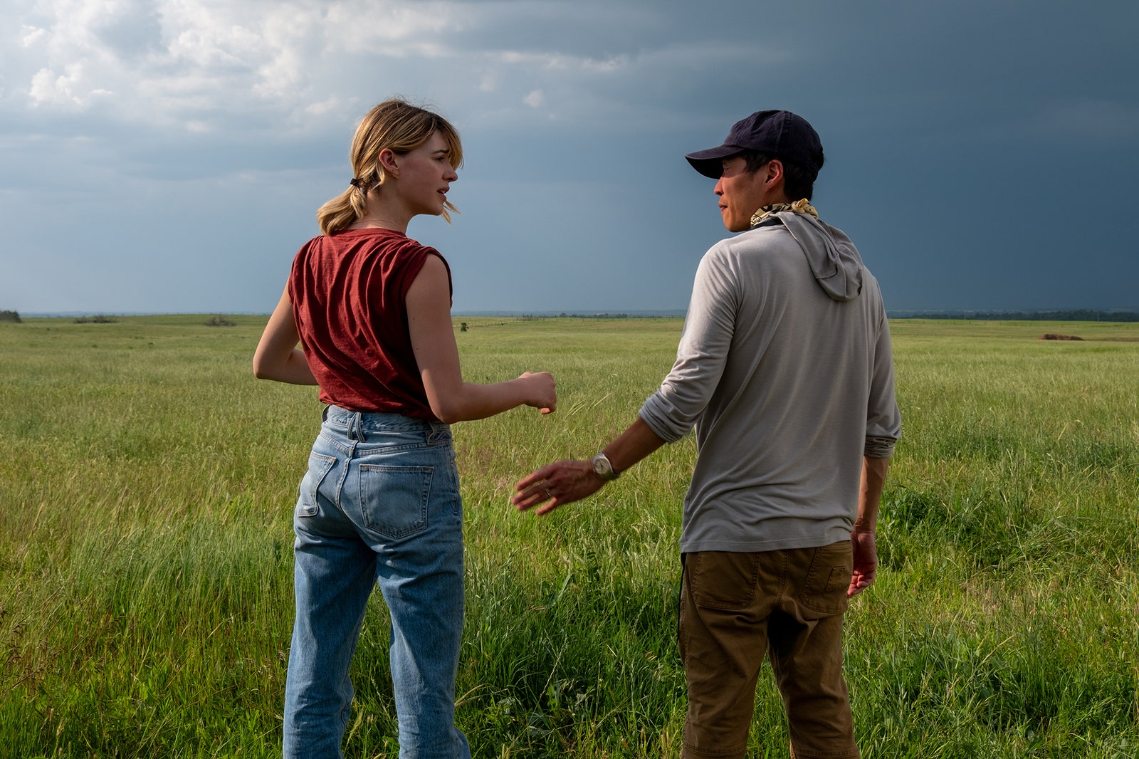 Image may contain Clothing Hat Body Part Hand Person Adult Pants Holding Hands Wristwatch Grass Plant and Field